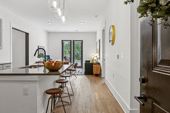 A modern kitchen with a bar area and a view of the backyard.